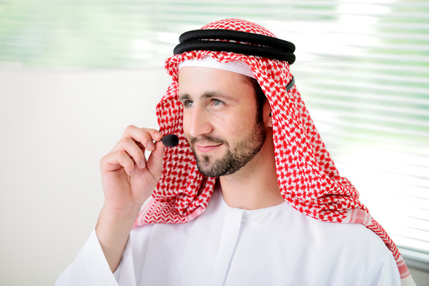 Retrato de un hombre de negocios árabe inteligente usando auriculares. Centro de llamadas
 - Foto, Imagen
