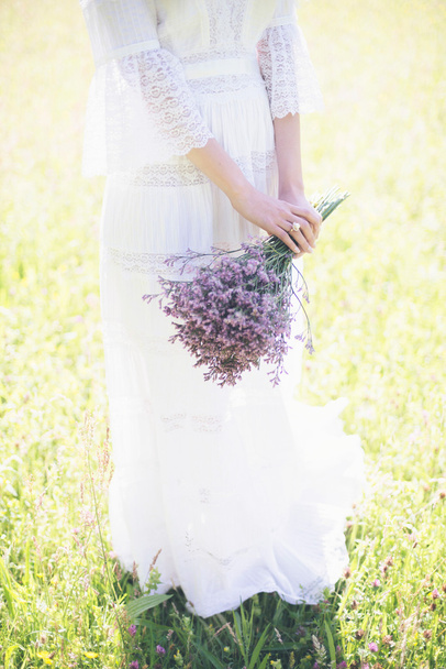 Bride holding purple flower bouquet - Foto, imagen
