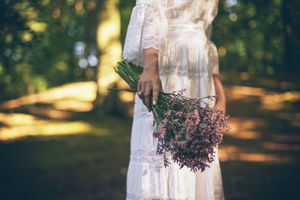 Bride holding purple flowers - Foto, afbeelding