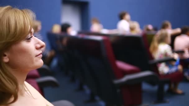 mujer sentada en una presentación en el teatro. vacaciones escolares
. - Metraje, vídeo