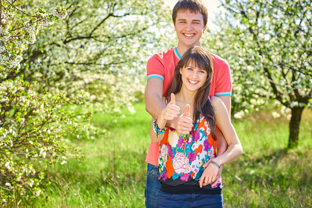 Young couple enjoying in blooming garden - Foto, imagen