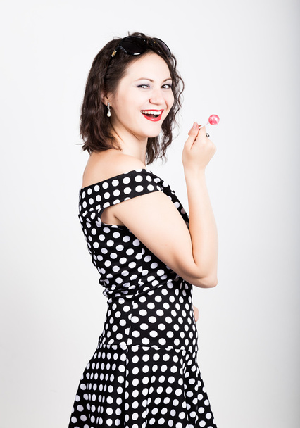 Portrait of happy beautiful young woman licking sweet candy and expressing different emotions. pretty woman with heart shaped lollipop - Фото, зображення