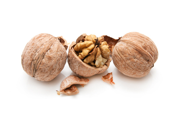 Walnut and a cracked walnut isolated on the white background - 写真・画像