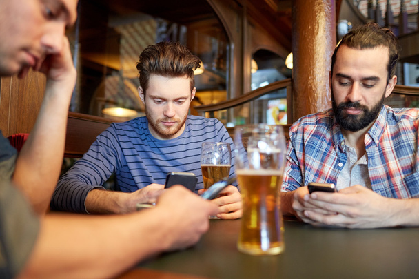 men with smartphones drinking beer at bar or pub - Foto, Imagem