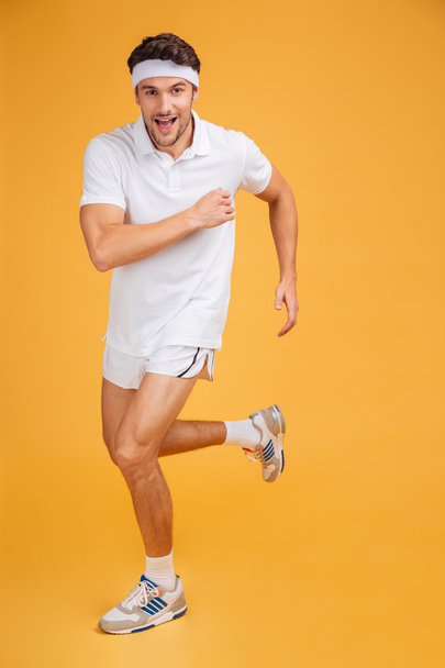 Full length of happy handsome young sportsman running - Photo, Image