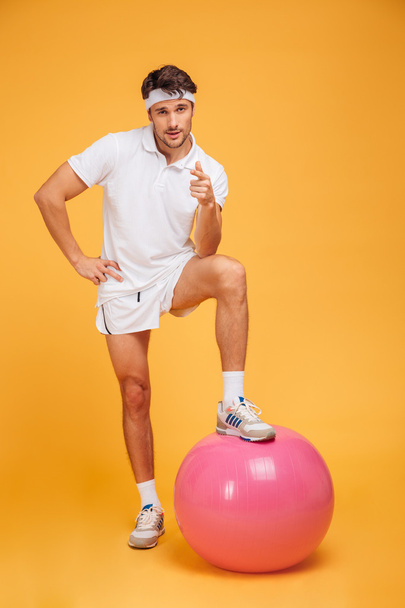 Young handsome sportsman with fitness ball pointing at camera - Fotoğraf, Görsel