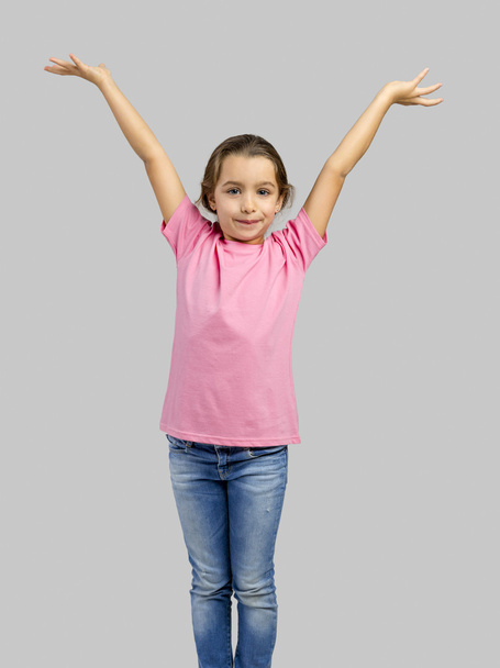 Happy little girl with arms raised on air  - Valokuva, kuva