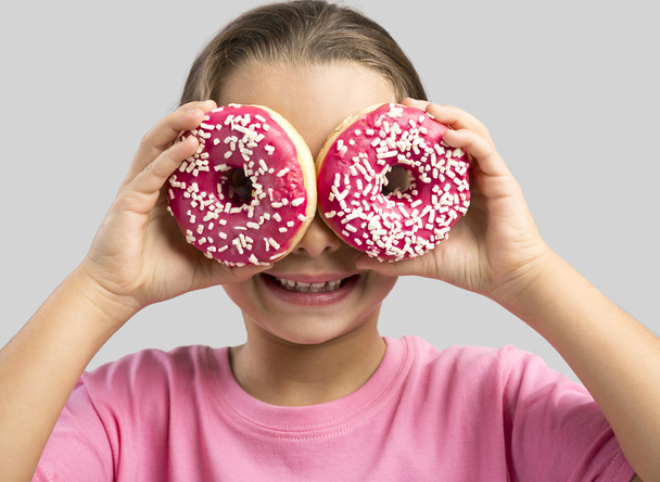 Girl looking through a donuts - Foto, Imagem