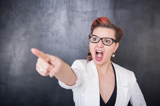 Angry screaming teacher pointing out on blackboard background - Foto, Bild