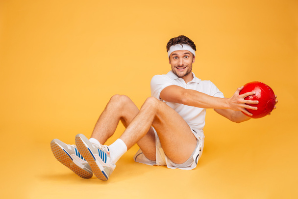 Sports man working out with fitness ball isolated - Foto, afbeelding