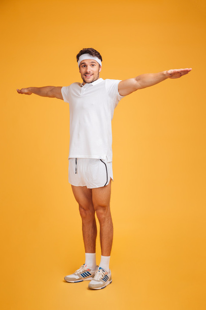 Happy young sportsman standing and doing exercises - Fotoğraf, Görsel