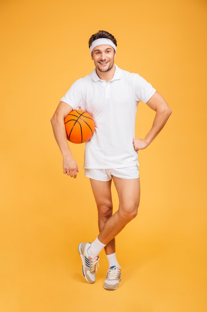 Happy young basketball player standing with ball - Fotoğraf, Görsel