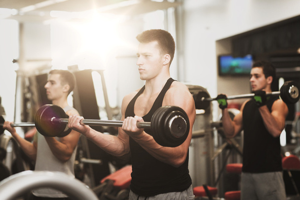 group of men with barbells in gym - Foto, Imagen