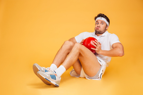 Funny sports man working out with fitness ball isolated - Zdjęcie, obraz