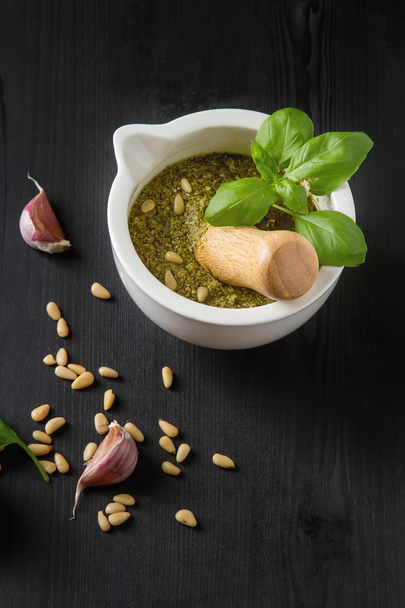 Homemade green pesto sauce with basil and pine nuts in white mor - Fotoğraf, Görsel