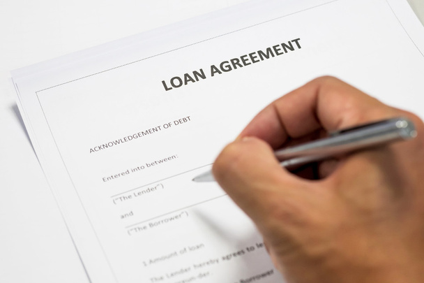 One writing on loan agreement document - Fotó, kép