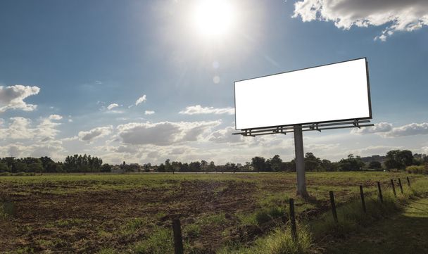Пустой рекламный щит перед красивым облачным небом в сельской местности
 - Фото, изображение