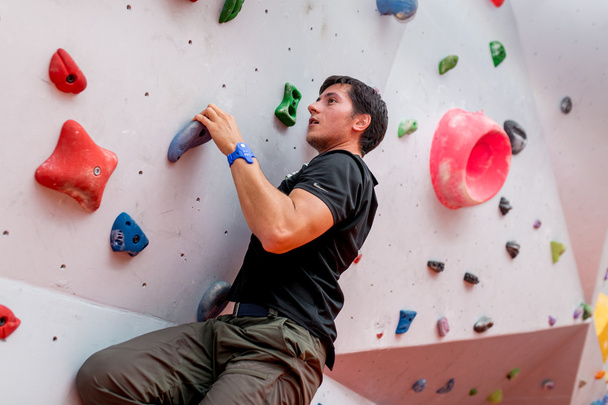 Homme grimpeur sur mur d'escalade artificiel
 - Photo, image