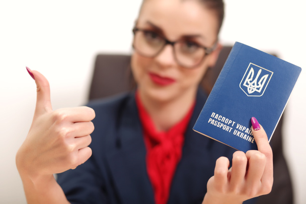 Gyönyörű fiatal nő, egy ukrán útlevél és emelt hüvelykujjával felfelé - Fotó, kép