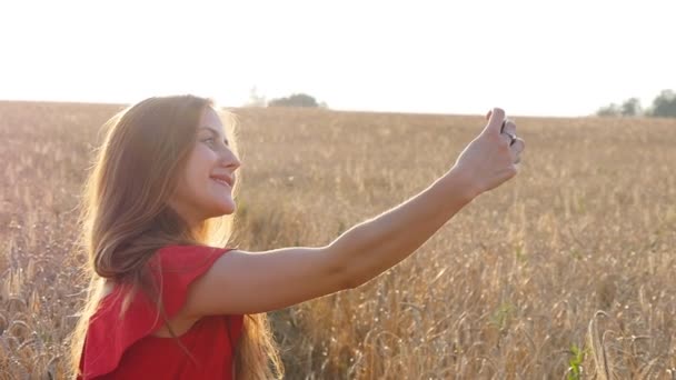 Beautiful woman taking selfie in yellow field - 映像、動画