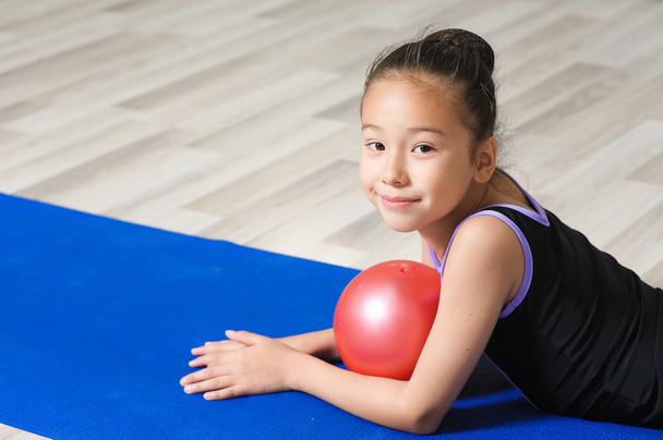 Πορτρέτο του γυμναστής νεαρό κορίτσι με κόκκινο μπάλα. - Φωτογραφία, εικόνα