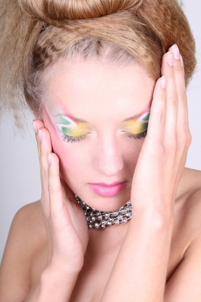 jonge vrouw met creatieve make-up en coiffure - Foto, afbeelding