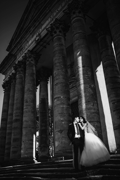 feliz pareja de boda de lujo está de pie y besándose en el stree
 - Foto, imagen