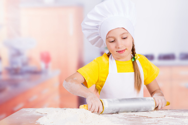 Children make the dough in the kitchen, roll a rolling pin - Фото, изображение