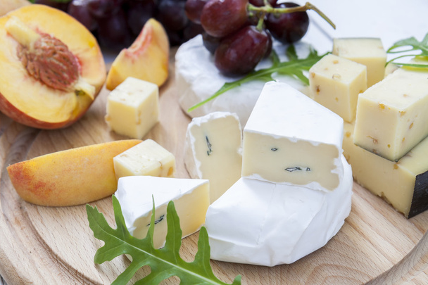 Finom sajtokat és gyümölcsök a fa kerek Tanács - Fotó, kép