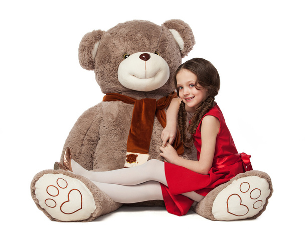 petite fille brune assise sur un gros jouet ours
 - Photo, image