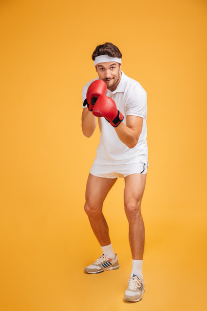 Concentrated young man boxer in red gloves ready to fight - Foto, Imagem