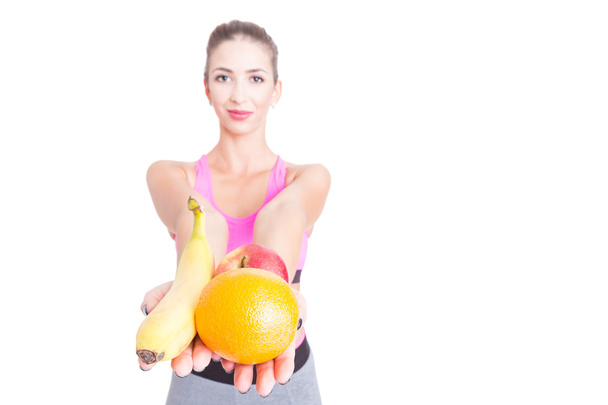 Selective focus of girl at gym holding fruits - Photo, Image