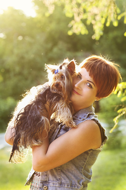 Beautiful young happy woman holding small dog in summer day walks in park - Fotografie, Obrázek