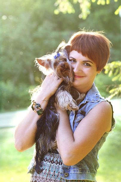Beautiful young happy woman holding small dog in summer day walks in park - Φωτογραφία, εικόνα