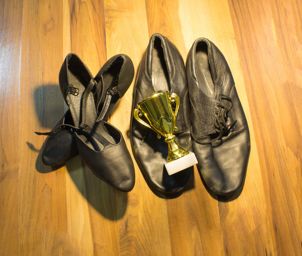 Černá Taneční obuv muže a ženy na dřevěné podlaze pozadí a zlatý pohár vítěz - Fotografie, Obrázek