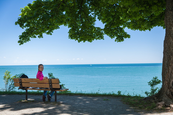 Jeune belle femme assise sur un banc sur la rive du lac et w
 - Photo, image