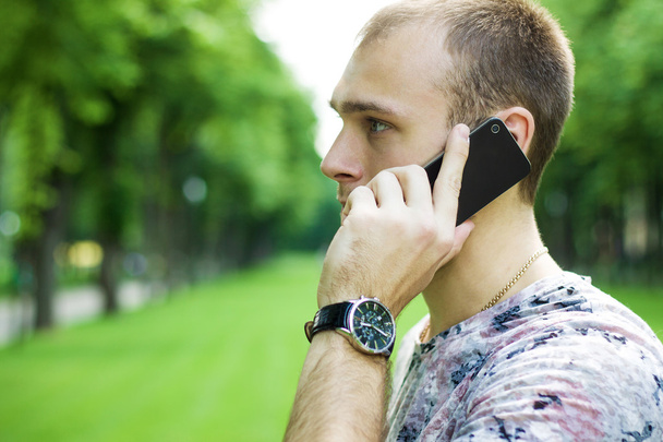 Hombre hablando por teléfono de cerca disparado en el jardín
 - Foto, Imagen