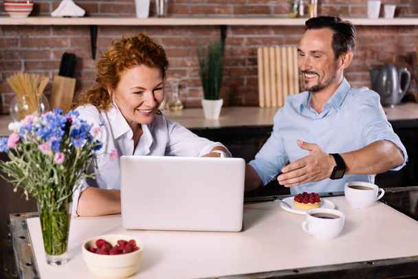 Couple looking at laptop while having breakfast - Photo, Image