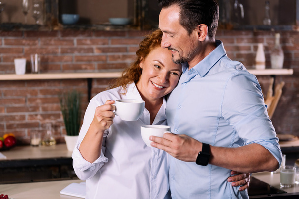 Woman and man hugging while drinking coffee - Foto, immagini