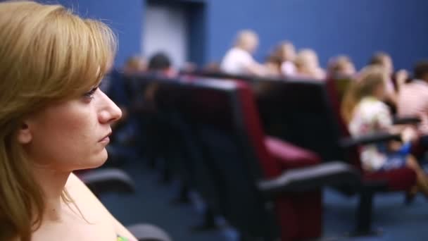 γυναίκα που κάθεται σε μια παρουσίαση στο θέατρο. σχολικές διακοπές. - Πλάνα, βίντεο