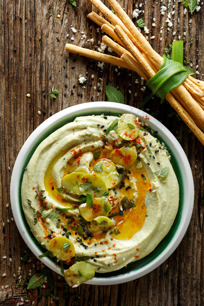 Broad bean hummus, with addition of olive oil, paprika powder, fresh mint and sesame seeds,  delicious and healthy vegan dip or spread - Photo, Image