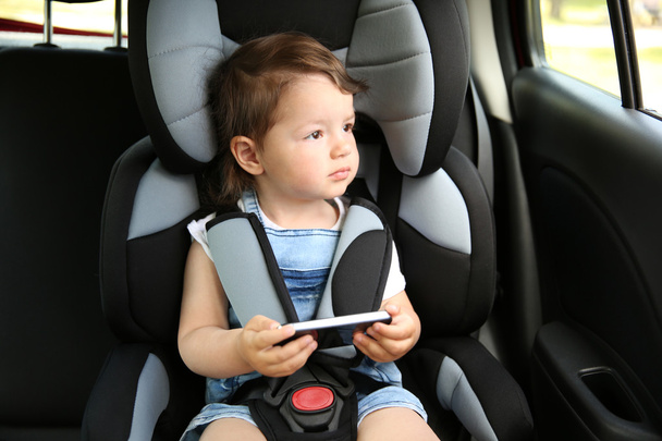 Boy sitting in a car in safety chair - Фото, изображение