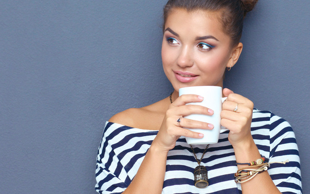 Portrait of young woman with cup tea or coffee - Фото, зображення