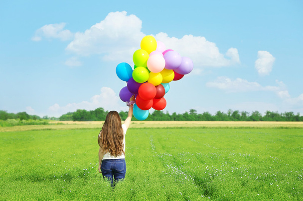 Femme heureuse avec des ballons colorés
  - Photo, image