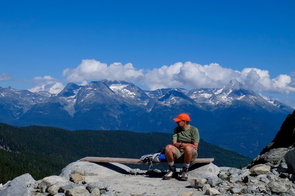 Homme randonneur assis sur le sommet de la montagne
.  - Photo, image