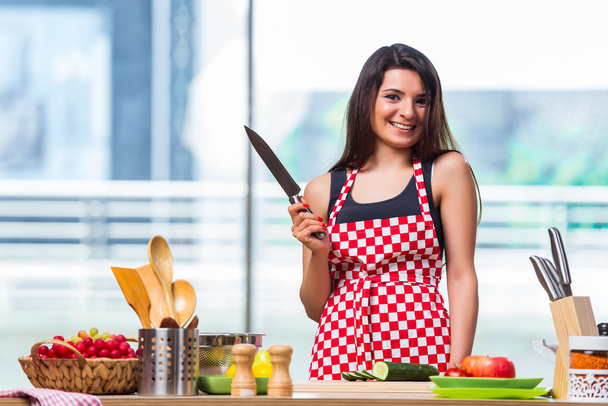 Mujer joven preparando ensalada en la cocina
 - Foto, Imagen