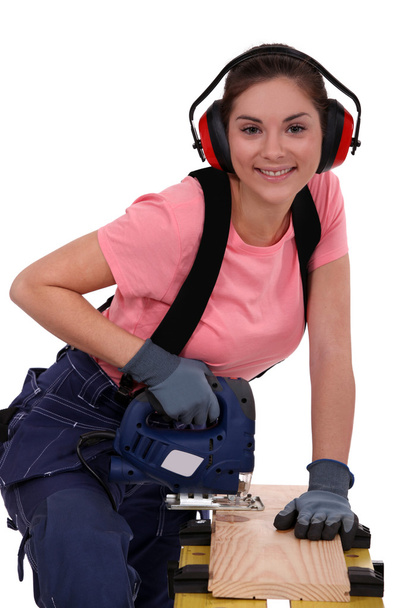 Tradeswoman using a jigsaw - Fotó, kép