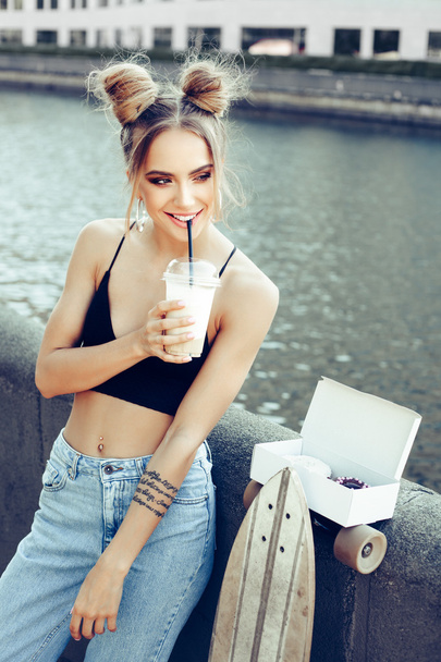 Young stylish woman drinking coffee in a city street - Foto, Bild