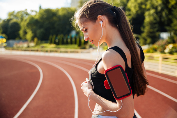 Side view of a female runner with mobile phone - Foto, Bild
