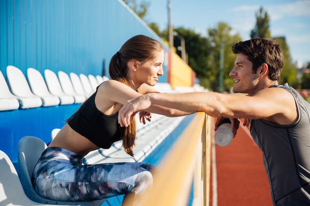 Young couple standing and talking on athletics track field - Foto, Imagem